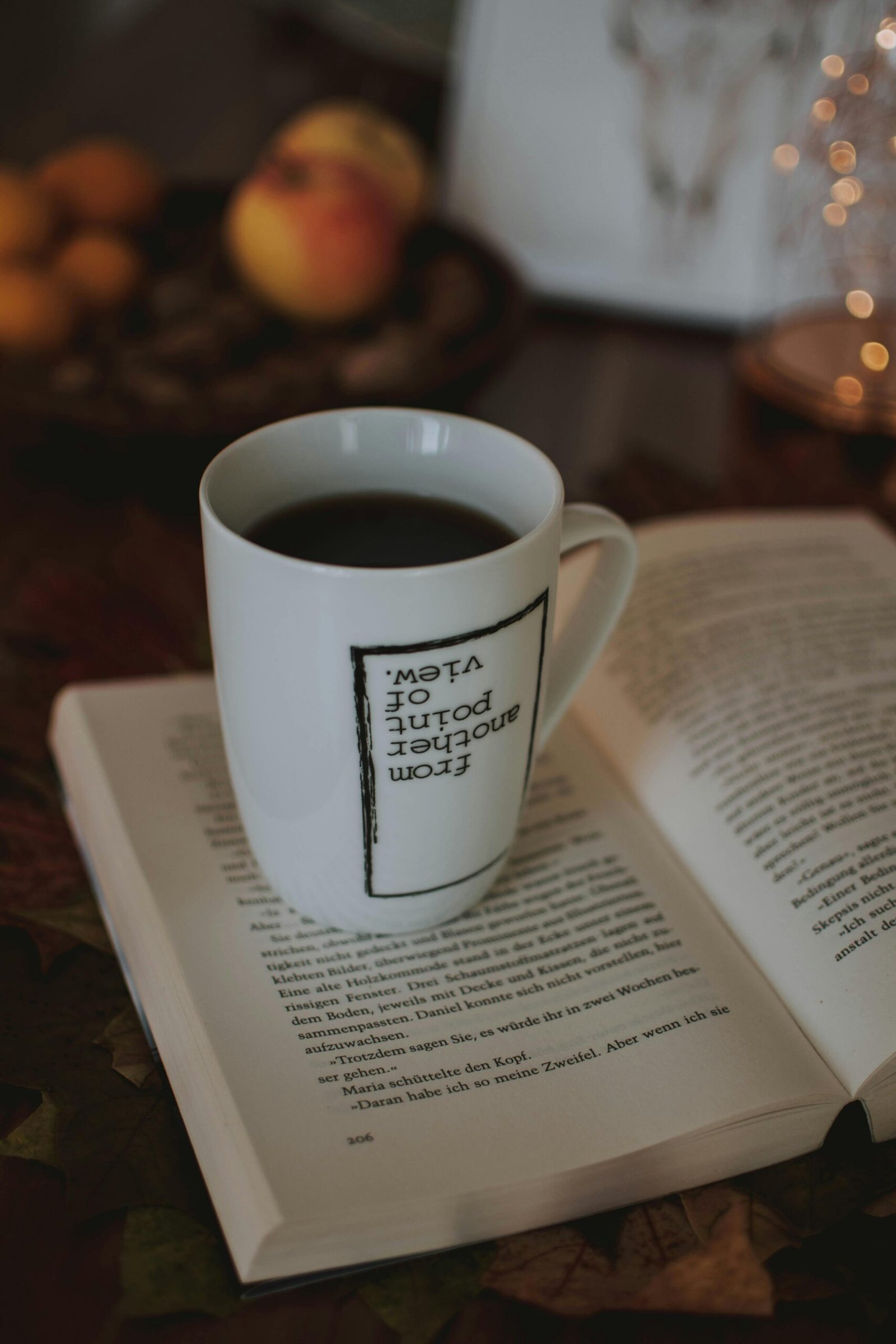A warm setting featuring a cup of coffee on an open book, capturing a cozy indoor atmosphere.